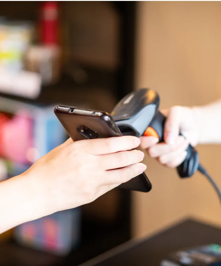 Customer paying by phone at a handheld card reader
