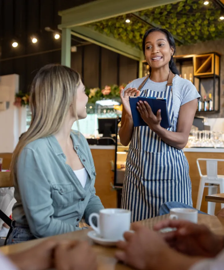 Cafe assistant serving a customer at the counter
