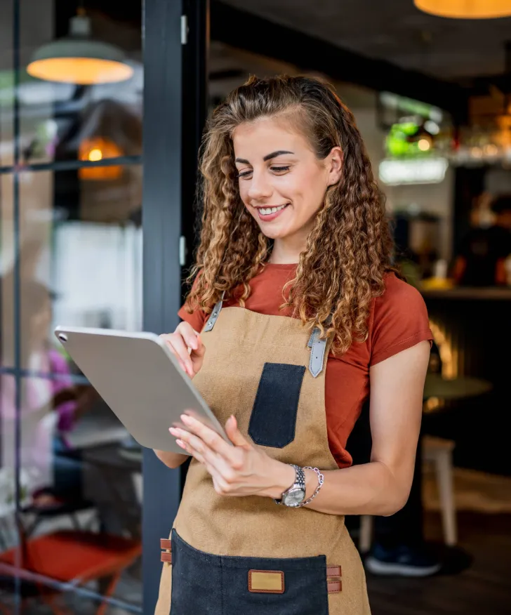 Cafe worker checking sales on a tablet