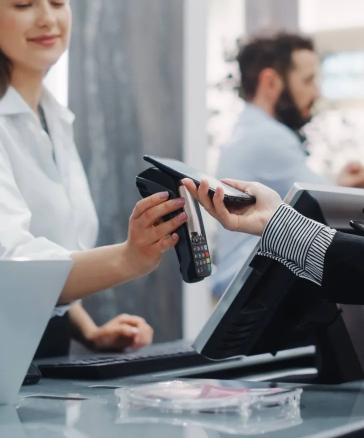 Shop assistant holding out a card reader for a customer to tap