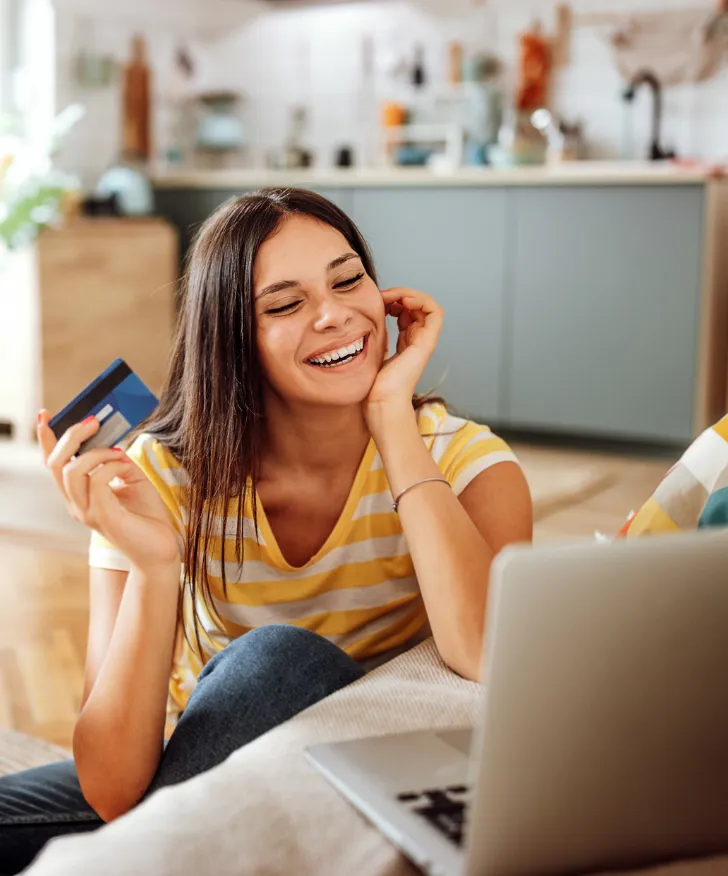 Customer with a bank card shopping on a laptop