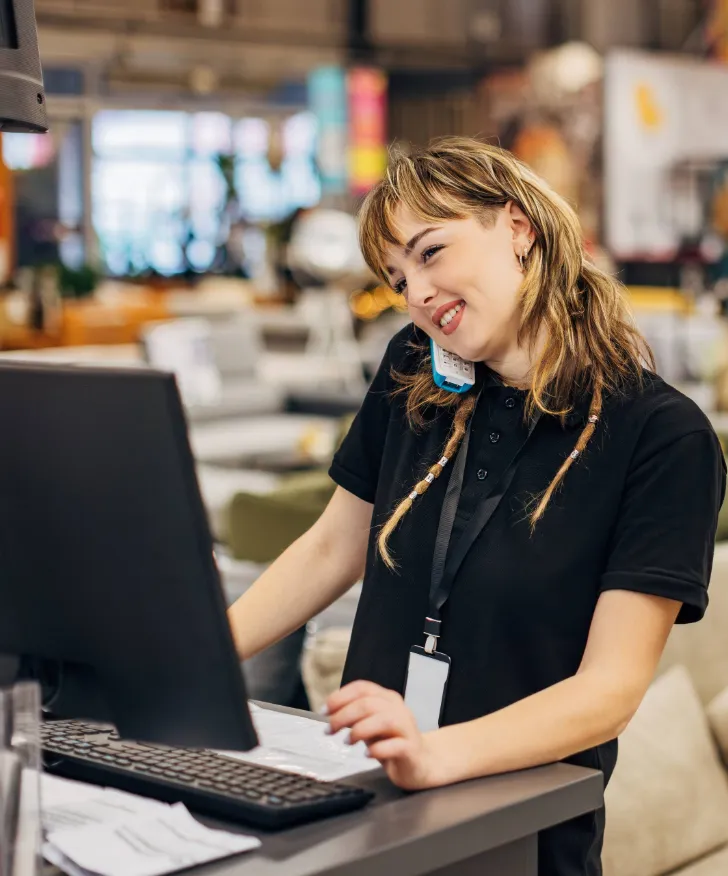Shop assistant taking a phone call at a store till