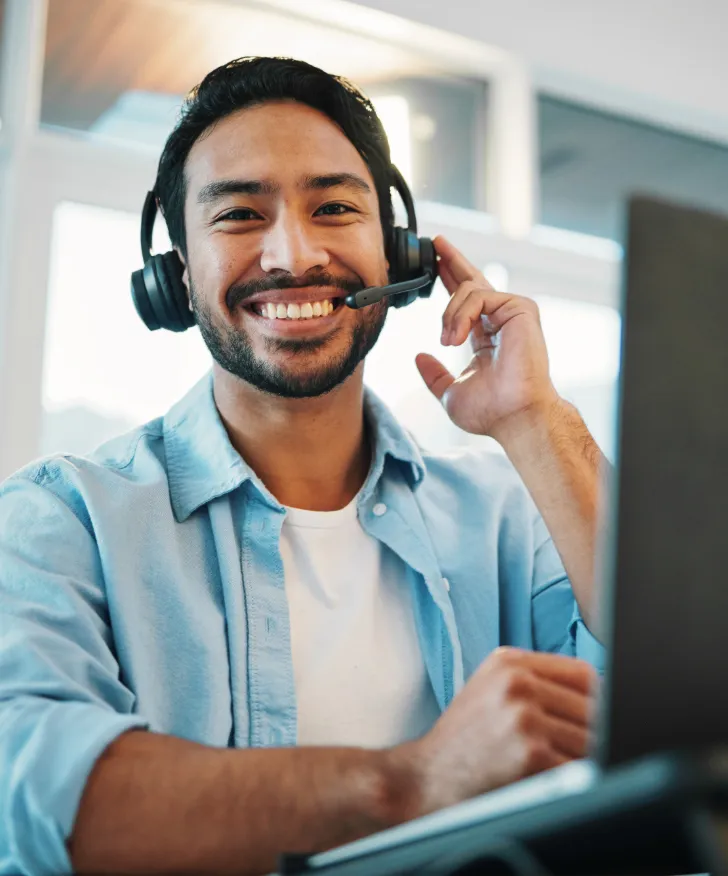 Smiling Swan support adviser adjusting his headset at his desk