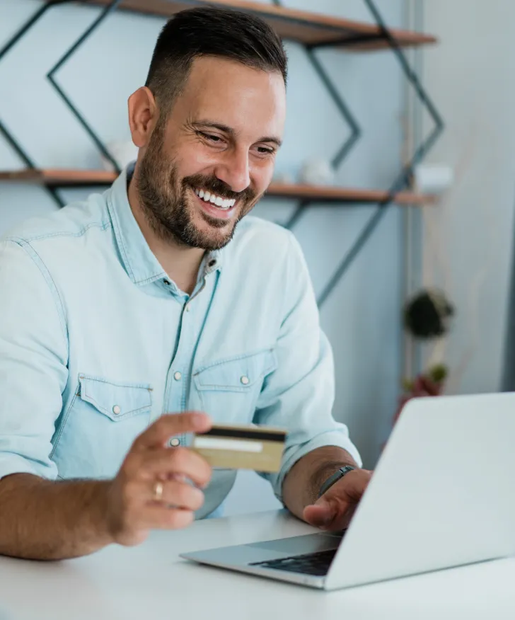 Retailer using a bank card at a laptop
